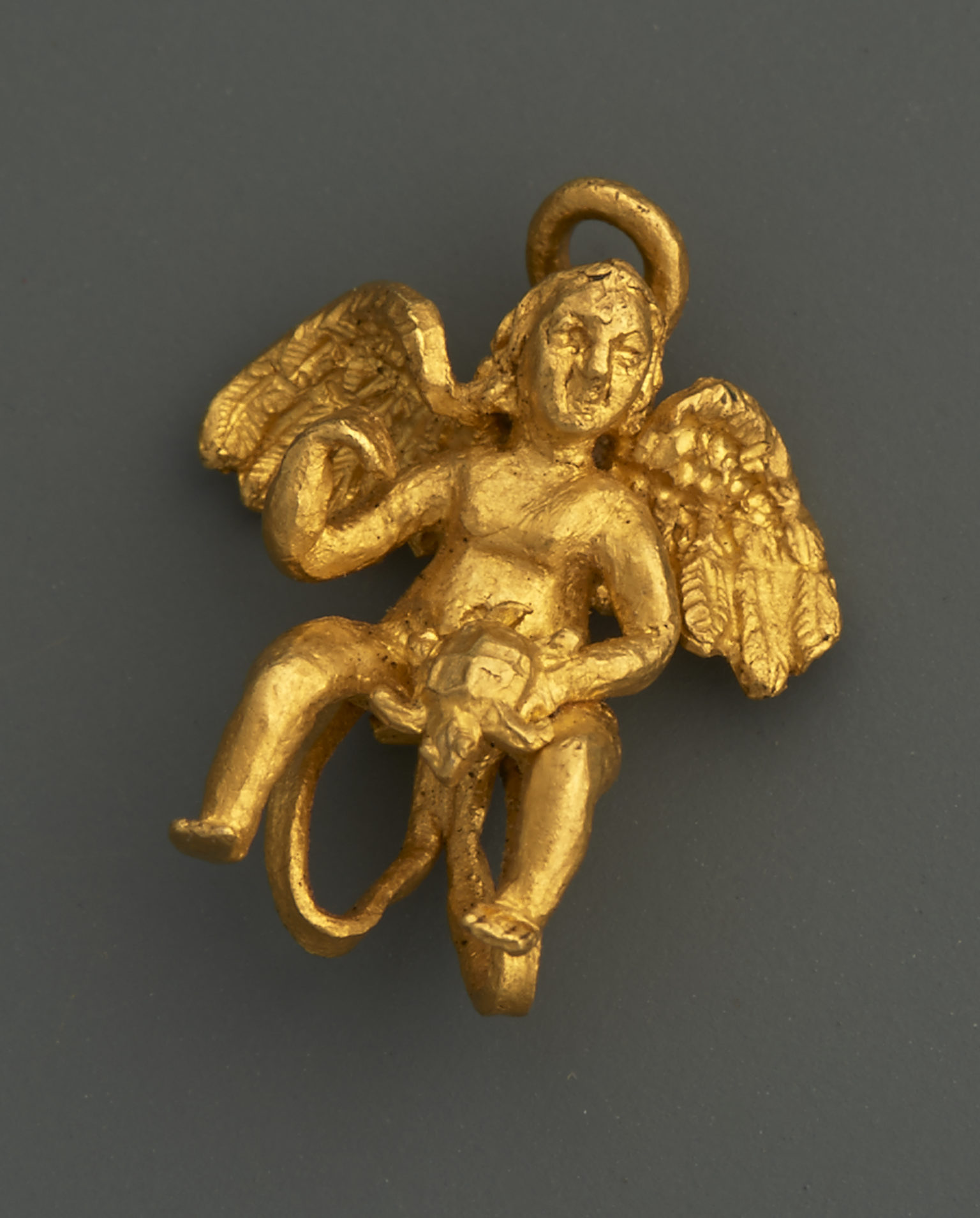 An Earring with Eros holding a Turtle